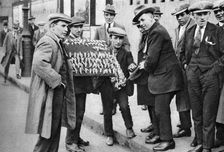 Street hawker selling football favours in King's Cross, London, 1911 (1926-1927)