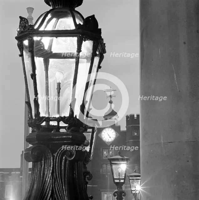 Street lamps at dusk, with the gatehouse of St James's Palace, City of Westminster, London, 1982. Creator: John Gay.