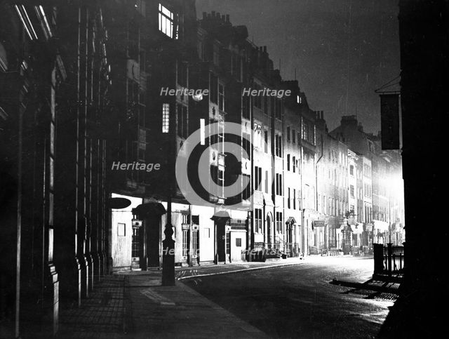 Street scene at night, Tottenham Court Road, Camden, London. Creator: Unknown.