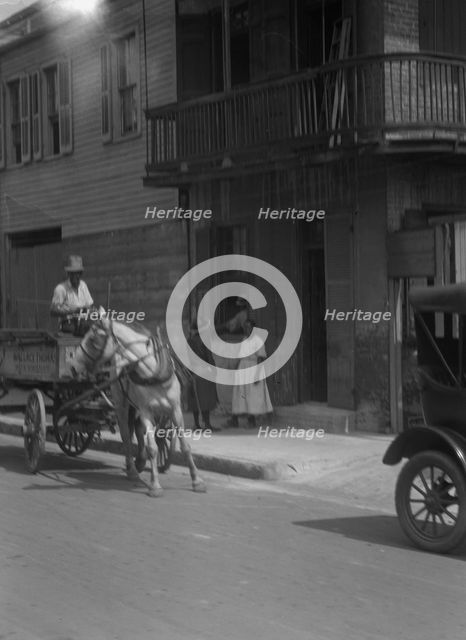 Street scene, including horse- or mule-drawn wagon, New Orleans, between 1920 and 1926. Creator: Arnold Genthe.