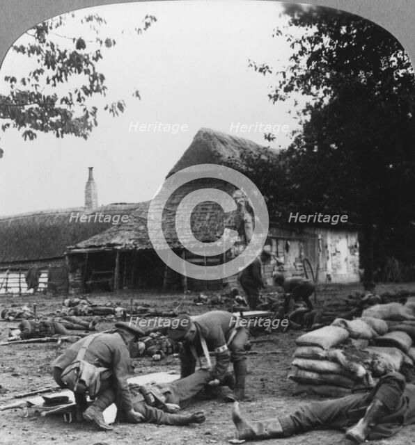 Stretcher bearers caring for wounded at an improvised first aid post, World War I, c1914-c1918.  Artist: Realistic Travels Publishers