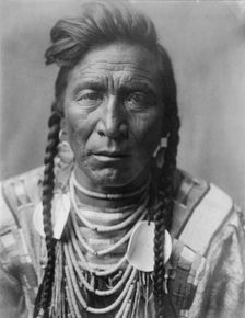 Strike On his Head, Crow Indian, Montana, head-and-shoulders portrait, facing front, loose..., c1908 Creator: Edward Sheriff Curtis