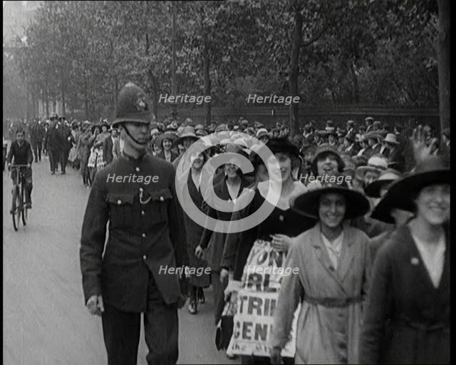 Striking Tea Shop Ladies Marching Down the Road, Flanked by Police, 1920. Creator: British Pathe Ltd.