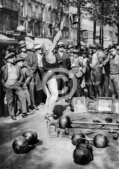 Strongman juggling with weights, Paris, 1931.Artist: Ernest Flammarion