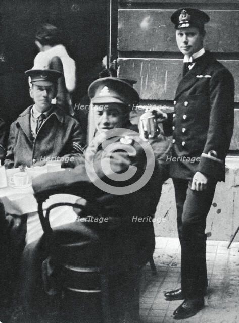 Sub-Lieutenant Prince Albert serving tea to wounded soldiers at Buckingham Palace, 1916. Artist: Unknown