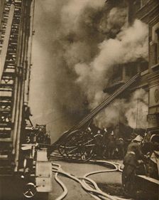 Subduing a Conflagration in a Narrow City Street c1935. Creator: Unknown