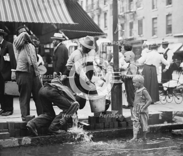 Summer scene, N.Y. - drinking water from street pump, between c1910 and c1915. Creator: Bain News Service.
