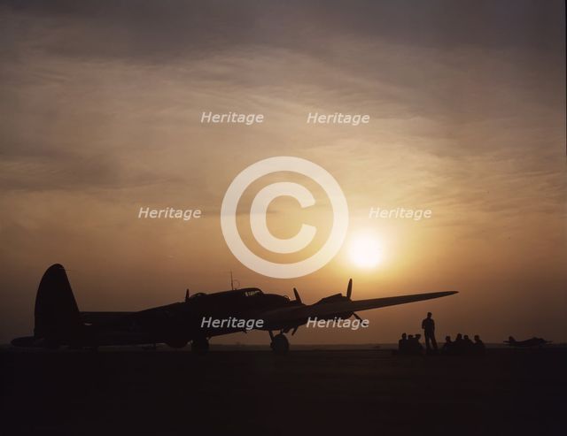Sunset silhouette of flying fortress, Langley Field, Va., 1942. Creator: Alfred T Palmer.