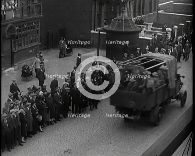 Supply Trucks With Armed Guards Driving Alongside a Crowd of Civilians, 1926. Creator: British Pathe Ltd.