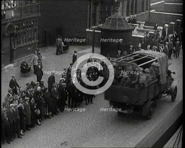 Supply Trucks With Armed Guards Driving Alongside a Crowd of Civilians, 1926. Creator: British Pathe Ltd.