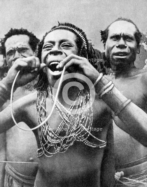 Swallowing canes in a ceremonial ritual, New Guinea, 1936.Artist: Wide World Photos