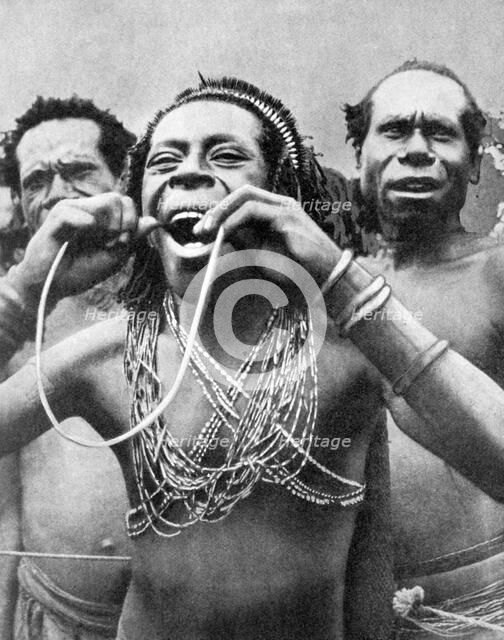 Swallowing canes in a ceremonial ritual, New Guinea, 1936.Artist: Wide World Photos