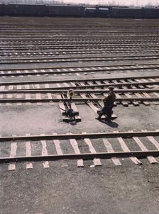 Switchman throwing a switch a C and NW RR's Proviso yard, Chicago, Ill., 1943. Creator: Jack Delano