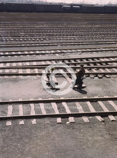Switchman throwing a switch a C and NW RR's Proviso yard, Chicago, Ill., 1943. Creator: Jack Delano.