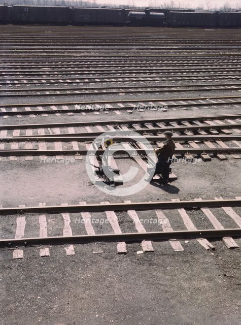 Switchman throwing a switch a C and NW RR's Proviso yard, Chicago, Ill., 1943. Creator: Jack Delano.