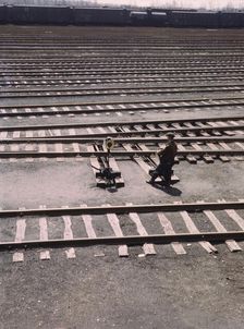 Switchman throwing a switch a C and NW RR's Proviso yard, Chicago, Ill., 1943. Creator: Jack Delano