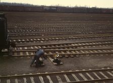 Switchman throwing a switch at C & NW RR's Proviso yard, Chicago, Ill., 1943. Creator: Jack Delano
