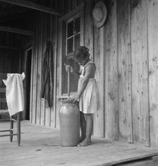 Pottery butter churn on porch of Negro tenant family, Randolph County, N Carolina, 1939. Creator: Dorothea Lange