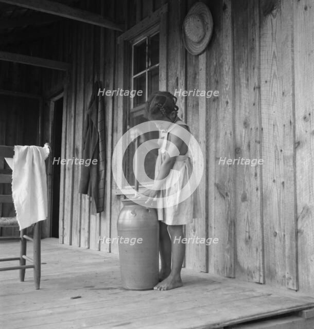 Pottery butter churn on porch of Negro tenant family, Randolph County, N Carolina, 1939. Creator: Dorothea Lange.