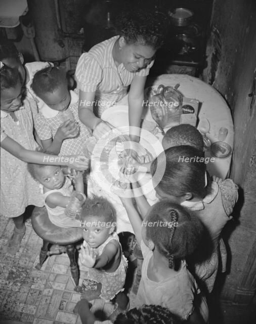 Pouring lemonade at a birthday party on Seaton Road, Washington, D.C., 1942. Creator: Gordon Parks.