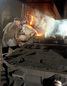 Pouring molten metal from a cupola into moulds, steel bath production, Hull, Humberside, 1965. Creator: Michael Walters