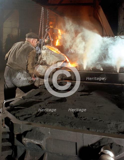 Pouring molten metal from a cupola into moulds, steel bath production, Hull, Humberside, 1965. Creator: Michael Walters.
