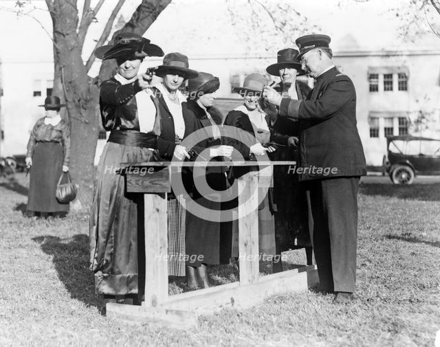 Police officer teaching women how to shoot, c. 1920.