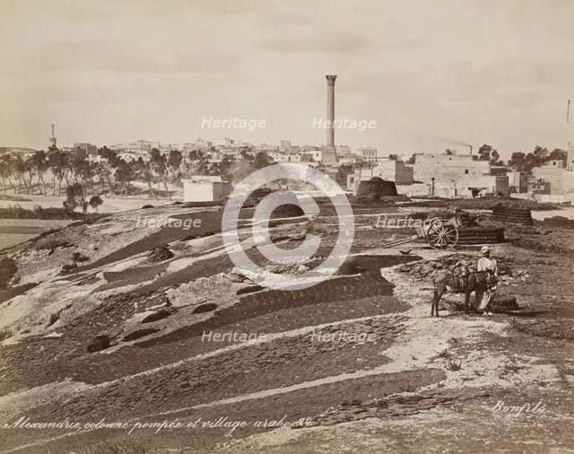 Pompey's Pillar and Arab Village at Alexandria, 19th century. Creator: Maison Bonfils.