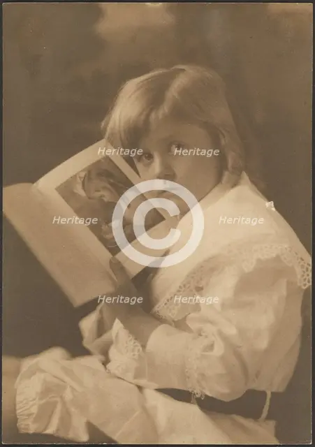 Portrait of Child Holding Book Open to Like Illustration, 1907-1943. Creator: Louis Fleckenstein.