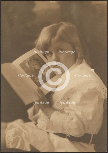 Portrait of Child Holding Book Open to Like Illustration, 1907-1943. Creator: Louis Fleckenstein.