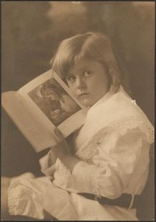 Portrait of Child Holding Book Open to Like Illustration, 1907-1943. Creator: Louis Fleckenstein