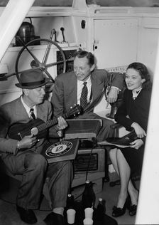 Portrait of Cliff Edwards, Betty Brewer, and Frank..., Ukelele Lady (yacht), Hudson River, NY, 1947. Creator: William Paul Gottlieb