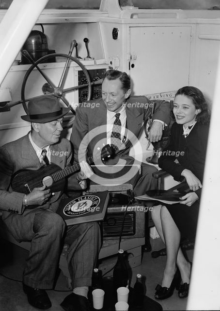 Portrait of Cliff Edwards, Betty Brewer, and Frank..., Ukelele Lady (yacht), Hudson River, NY, 1947. Creator: William Paul Gottlieb.