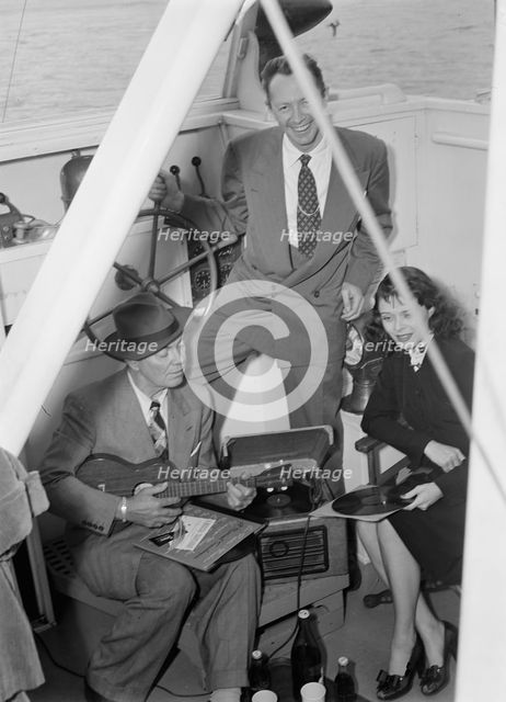 Portrait of Cliff Edwards, Betty Brewer, and Frank...Ukelele Lady (yacht), Hudson River, N.Y., 1947. Creator: William Paul Gottlieb.