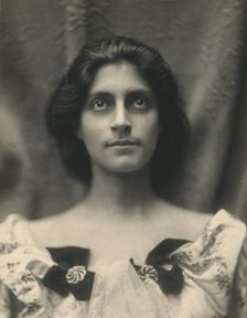 Portrait of a woman in a floral dress adorned with diamond brooches and bows, c1900. Creator: Virginia M Prall