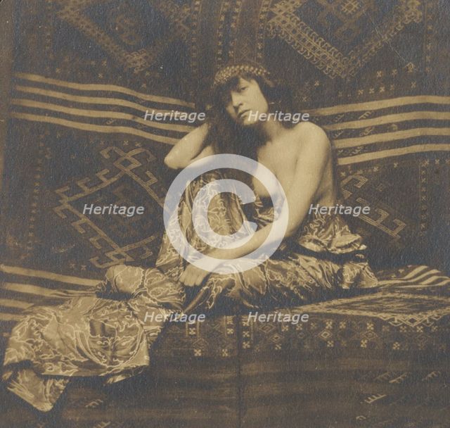 Portrait of a woman, partially draped, seated on a sofa, 1900. Creator: Unknown.