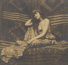 Portrait of a woman, partially draped, seated on a sofa, 1900. Creator: Unknown