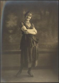 Portrait of a Woman Standing Before Tapestry, 1907-1943. Creator: Louis Fleckenstein