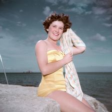Portrait of a young woman in a swimsuit by the sea, c1955. Creator: Arthur Charles Kirby Ware