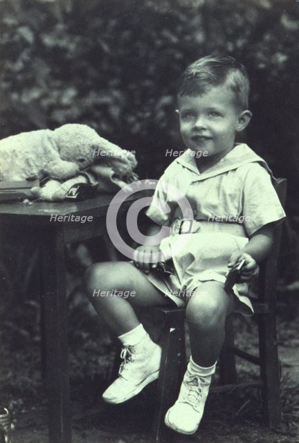 Portrait of a young boy seated at an outdoor table, facing front, between 1940 and 1950. Creator: Joseph Woodson Whitesell.