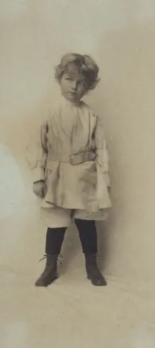 Portrait of a young boy standing in short pants and belted shirt, c1900. Creator: Misses Selby