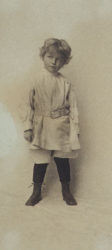 Portrait of a young boy standing in short pants and belted shirt, c1900. Creator: Misses Selby