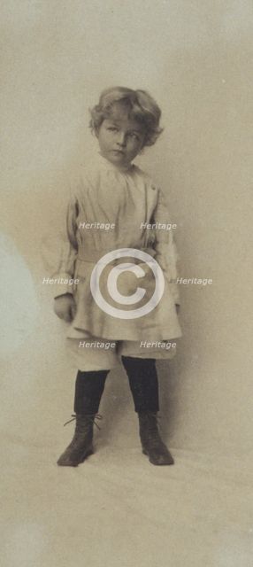 Portrait of a young boy standing in short pants and belted shirt, c1900. Creator: Misses Selby.