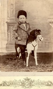 Portrait of a boy sitting on a toy horse, late 19th cent - early 20th cent. Creator: Unknown