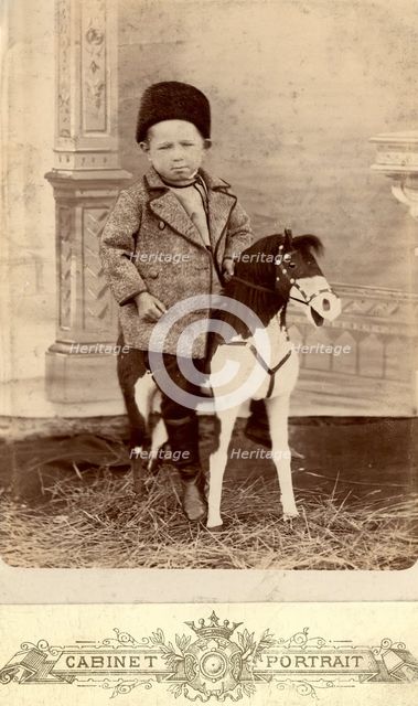 Portrait of a boy sitting on a toy horse, late 19th cent - early 20th cent. Creator: Unknown.