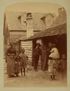 Portrait of a Black family standing in front of a house, 1886. Creator: George Barker
