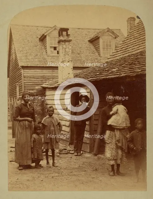 Portrait of a Black family standing in front of a house, 1886. Creator: George Barker.