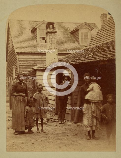 Portrait of a Black family standing in front of a house, 1886. Creator: George Barker.