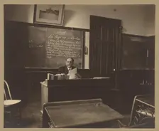 Portrait of a male mathematics teacher with moustache seated at his classroom desk, about 1900. Creator: Unknown