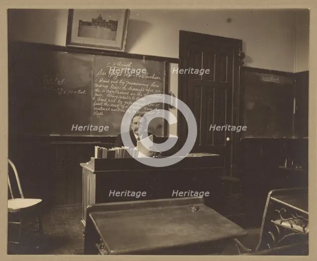 Portrait of a male mathematics teacher with moustache seated at his classroom desk, about 1900. Creator: Unknown.